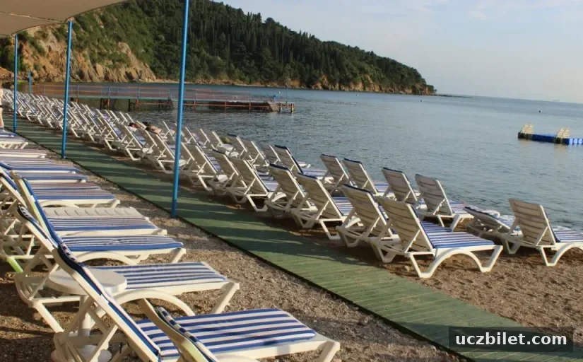 deniz manzarası eşliğinde kumsalda yer alan şezlonglar